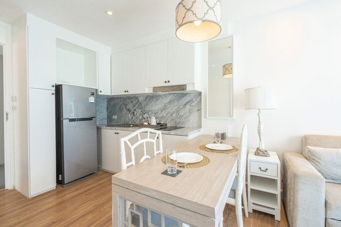 Fitted kitchen with island table and refrigerator