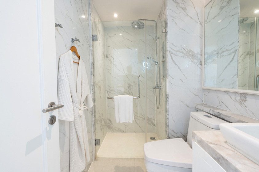 Marble-finished bathroom with walk-in shower